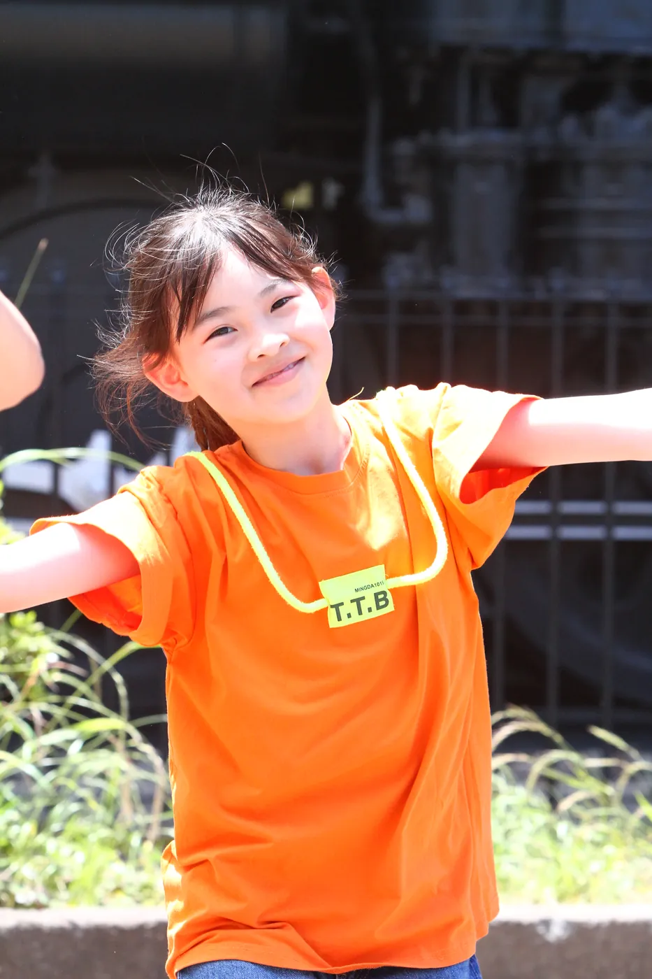 オレンジのTシャツで笑顔いっぱいのキッズダンサー